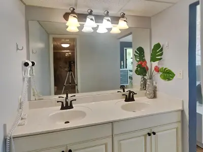 a bathroom with two sinks and a large mirror at Edgewater Tower III #704 in Panama City Beach