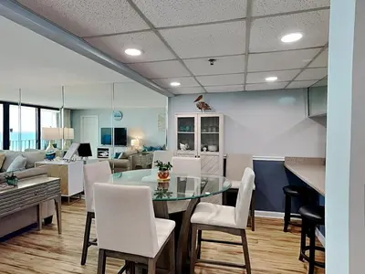 a dining room and living room with a table and chairs at Edgewater Tower III #704 in Panama City Beach