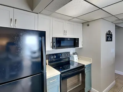 a kitchen with a black stove and a microwave at Edgewater Tower III 707 in Panama City Beach