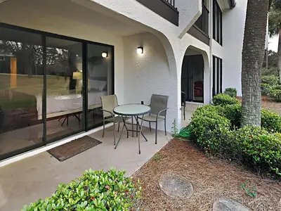 a patio with a table and chairs outside of a house at Edgewater Villa #704 in Panama City Beach