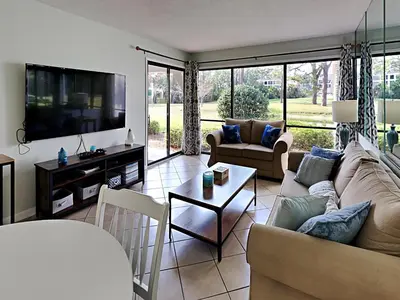a living room with a couch and a tv at Edgewater Villa #704 in Panama City Beach