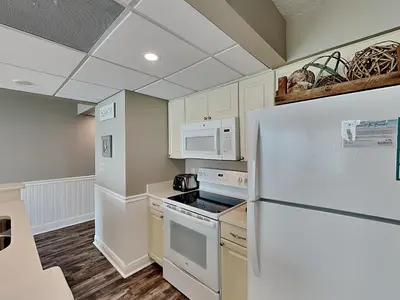 a kitchen with white appliances and a refrigerator at Edgewater Tower III 1006 in Panama City Beach