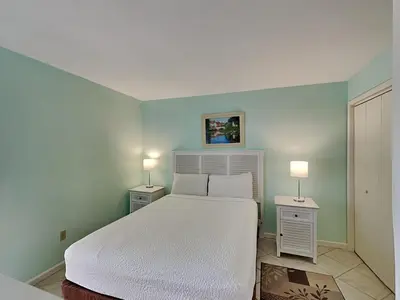 a bedroom with a white bed and two night stands at Edgewater Tower III 1106 in Panama City Beach