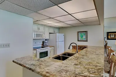 a kitchen with marble counter tops and a sink at Edgewater Tower III 1108 in Panama City Beach