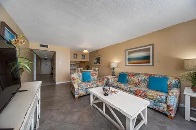 a living room with a couch and a table at Edgewater Leeward #302 in Panama City Beach
