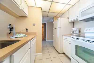 a kitchen with white cabinets and a sink at Edgewater Leeward #302 in Panama City Beach