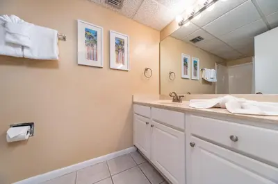 a bathroom with a sink and a mirror at Edgewater Leeward #302 in Panama City Beach