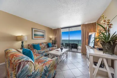 a living room with a couch and a table at Edgewater Leeward #302 in Panama City Beach
