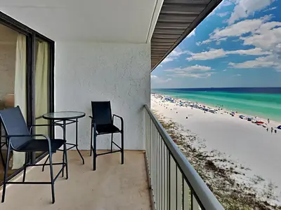 a balcony with two chairs and a table and the beach at Edgewater Leeward #605 in Panama City Beach