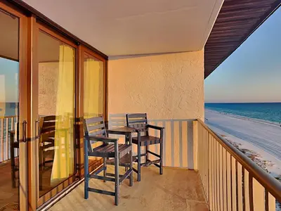 a balcony with a table and chairs on the beach at Edgewater Leeward #605 in Panama City Beach