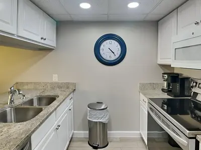 a kitchen with a sink and a clock on the wall at Edgewater Leeward #605 in Panama City Beach