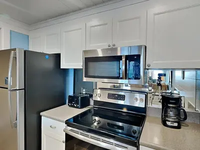 a kitchen with a stove and a refrigerator at Edgewater Windward #304 in Panama City Beach