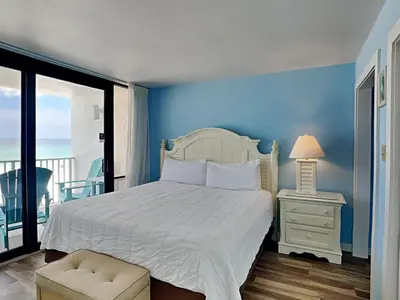 a bedroom with a bed with a blue wall at Edgewater Windward #304 in Panama City Beach