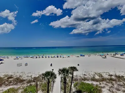 a beach with palm trees and the ocean at Edgewater Windward #304 in Panama City Beach