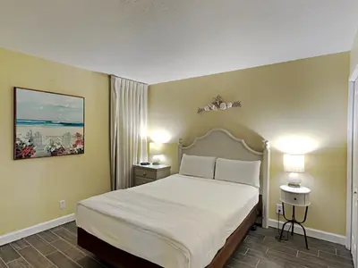 a bedroom with a large white bed with two lamps at Edgewater Windward #305 in Panama City Beach
