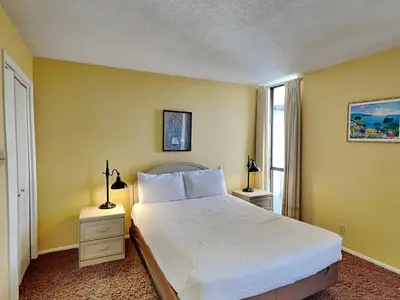 a bedroom with a white bed and two night stands at Edgewater Windward #602 in Panama City Beach
