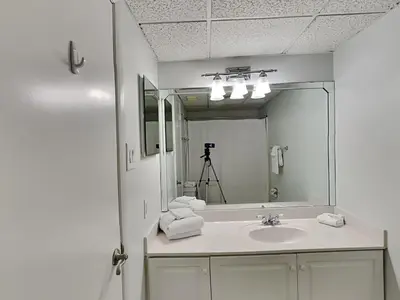 a white bathroom with a sink and a mirror at Edgewater Windward #603 in Panama City Beach