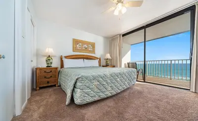 a bedroom with a bed and a large window at Edgewater Windward #603 in Panama City Beach