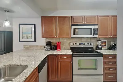 a kitchen with a stove and a microwave at Edgewater Villa #306 in Panama City Beach