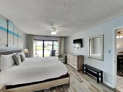 a bedroom with a large bed and a television at Edgewater Villa #306 in Panama City Beach