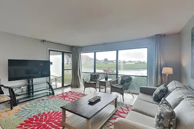 a living room with a couch and a tv at Edgewater Villa #306 in Panama City Beach