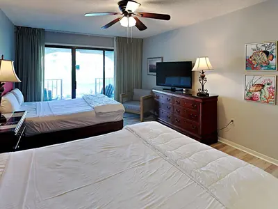 a bedroom with two beds and a flat screen tv at Edgewater Villa #404 in Panama City Beach
