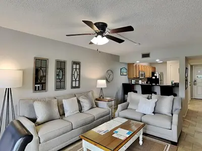a living room with two couches and a ceiling fan at Edgewater Villa #404 in Panama City Beach