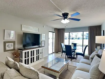 a living room with a couch and a flat screen tv at Edgewater Villa #404 in Panama City Beach