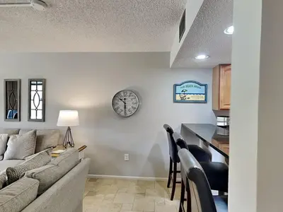 a living room with a couch and a clock on the wall at Edgewater Villa #404 in Panama City Beach