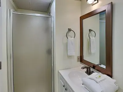 a bathroom with a sink and a shower and a mirror at Edgewater Villa #703 in Panama City Beach