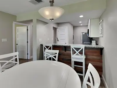a kitchen with a counter and stools in a room at Edgewater Villa #708 in Panama City Beach
