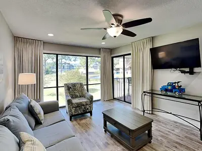 a living room with a couch and a ceiling fan at Edgewater Villa #708 in Panama City Beach