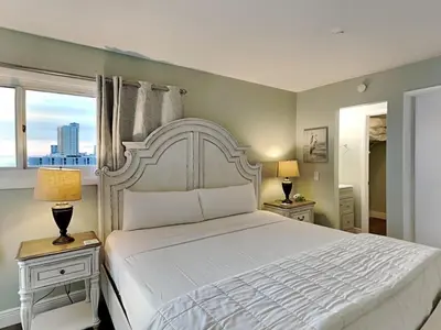 a bedroom with a large white bed with two night stands at Summit Beach Resort #901 in Panama City Beach