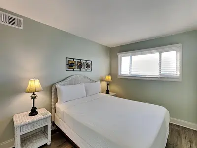 a bedroom with a white bed and a window at Summit Beach Resort #901 in Panama City Beach