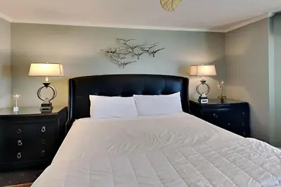 a bedroom with a bed with two nightstands and two lamps at Edgewater Tower II 901 in Panama City Beach