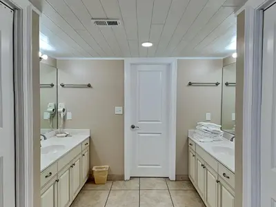 a white bathroom with two sinks and a mirror at Edgewater Tower II 801 in Panama City Beach