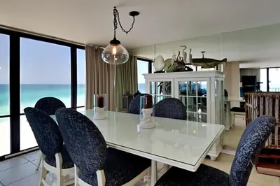 a dining room with a white table and chairs at Edgewater Tower II 801 in Panama City Beach