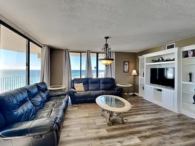 a living room with a blue couch and a tv at Edgewater Tower III 1114 in Panama City Beach