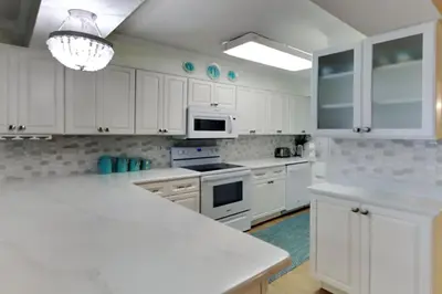 a kitchen with white cabinets and a white counter top at Regency Towers 1202 in Panama City Beach