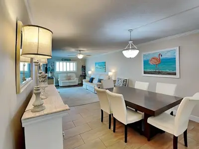 a dining room and living room with a table and chairs at Regency Towers 1202 in Panama City Beach