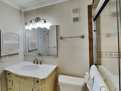 a bathroom with a sink and a toilet and a mirror at Regency Towers 1202 in Panama City Beach