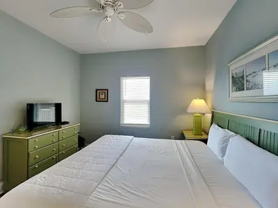 a bedroom with a large white bed with a ceiling fan at Laketown Wharf 1907 in Panama City Beach