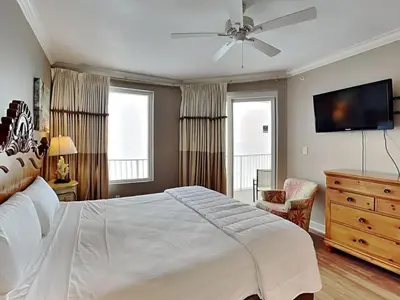 a bedroom with a large bed with a ceiling fan at Grandview East #1005 in Panama City Beach