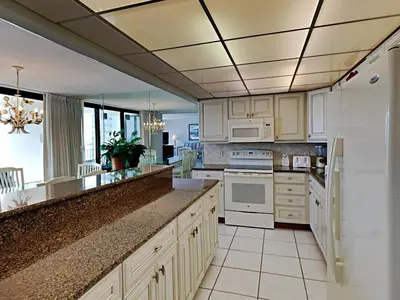 a kitchen with white cabinets and white appliances at Edgewater Tower I 807 in Panama City Beach