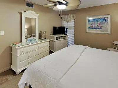 a bedroom with a white bed and a mirror at Edgewater Tower I 907 in Panama City Beach