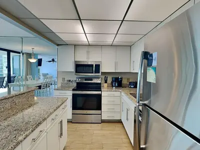 a kitchen with white cabinets and a refrigerator at Edgewater Tower I 907 in Panama City Beach