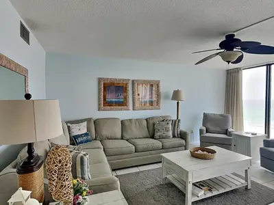 a living room with a couch and a table at Edgewater Tower I 907 in Panama City Beach