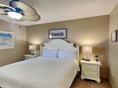 a bedroom with a white bed and two night stands at Edgewater Tower I 907 in Panama City Beach