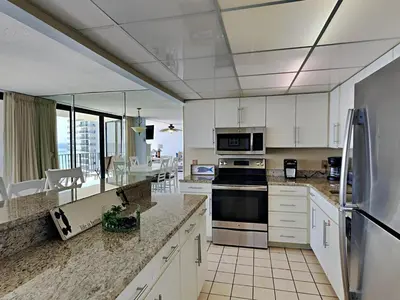 a kitchen with white cabinets and appliances with a view at Edgewater Tower I 907 in Panama City Beach