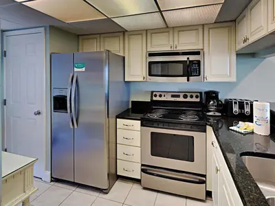 a kitchen with stainless steel appliances and white cabinets at Edgewater Tower I 1010 in Panama City Beach